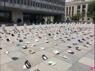 The image shows a millions missing event, with shoes laid out across the ground covering a large space to show how many people with ME are missing from daily life.