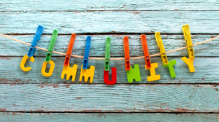 Plastic letters spelling out 'community' in primary colours and pegged onto a washing line.