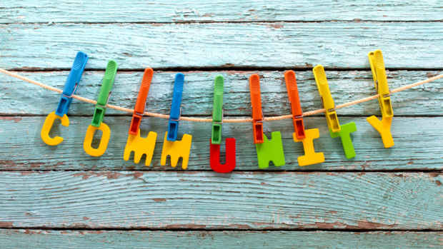 Plastic letters spelling out 'community' in primary colours and pegged onto a washing line.