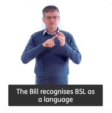 A still from video of Des using British Sign Language to say 'The Bill recognises BSL as a language'.