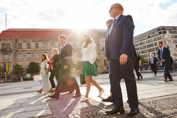 The delegation are walking through the streets towards the conference centre.